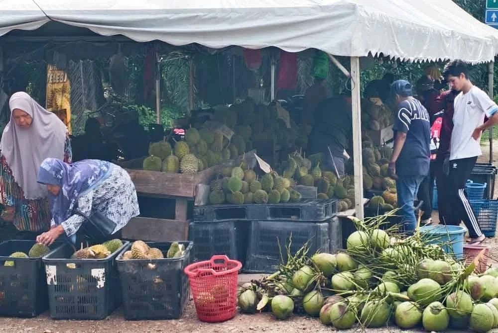 Orang ramai memilih durian di sebuah gerai di Rembau.