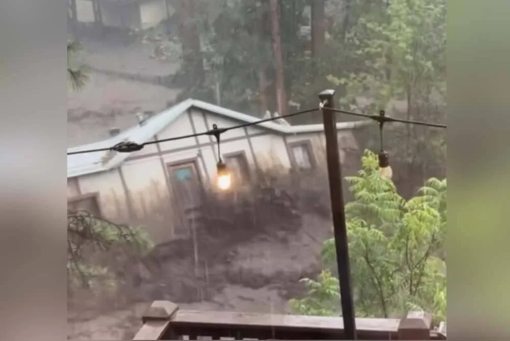 Video di media sosial menunjukkan air deras menghanyutkan sebuah rumah sepenuhnya.