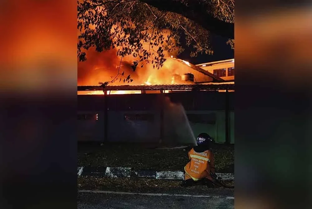 Seorang anggota PBS melakukan pancuran air bagi mengawal kebakaran.