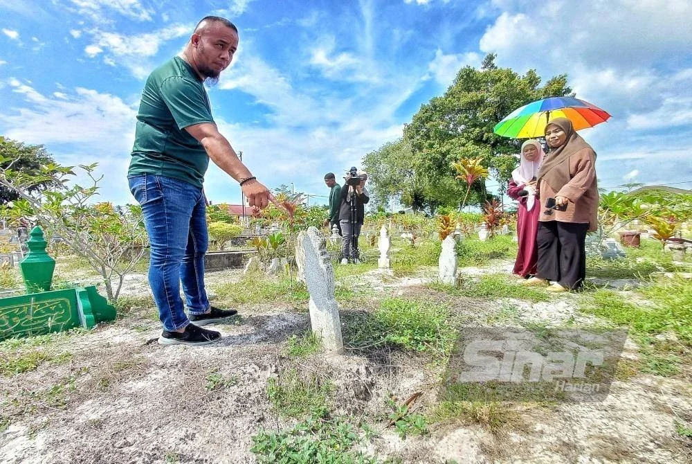 Adi Akbar menunjukkan tompokan lubang di kawasan kubur yang berlaku setiap kali musim hujan. Foto Sinar Harian