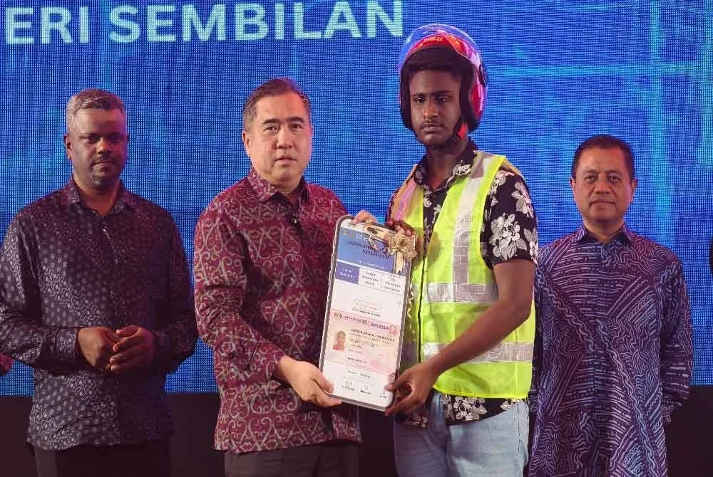 Anthony menyerahkan replika lesen kepada peserta Program MyLesen B2.