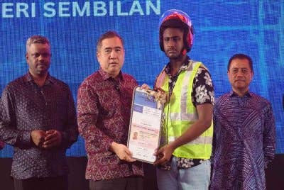 Anthony menyerahkan replika lesen kepada peserta Program MyLesen B2.