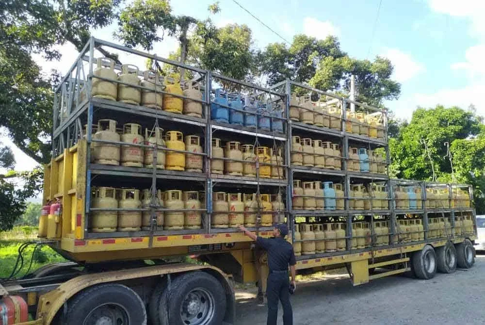 Anggota penguat kuasa KPDN Pahang melakukan pemeriksaan ke atas treler membawa tong gas yang berada di kawasan premis di Jalan Mancis, Bsntong yang digempur pada Khamis.