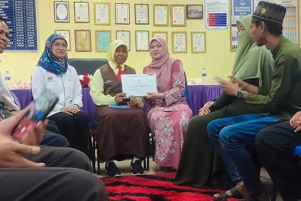 Fadhlina menyerahkan sumbangan insurans takaful dan sumbangan kebajikan kepada Putri Qisya di Sekolah Kebangsaan Seberang Perak Baru, Alor Setar pada Ahad.