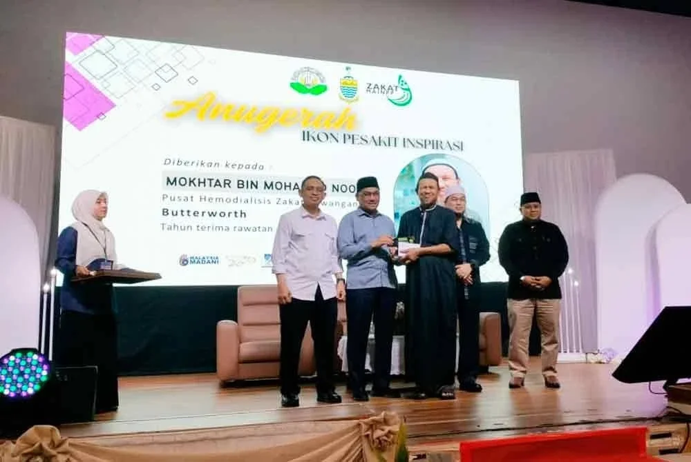 Rosidi menyampaikan anugerah ikon pesakit inspirasi kepada Mokhtar Mohamad Noor pada majlis himpunan pesakit dialisis tajaan Zakat MAINPP di Dewan Al-Ansar pada Ahad.