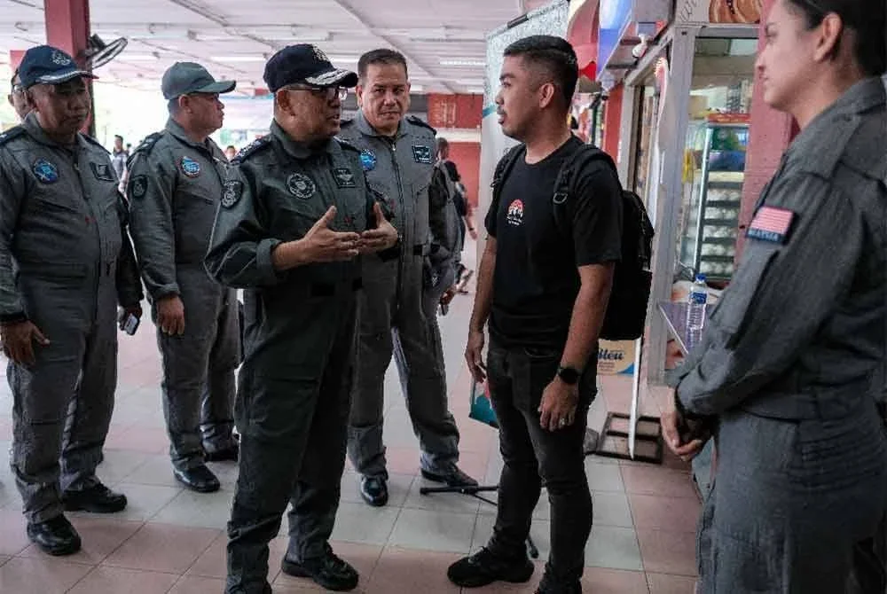 Noor Sham (tengah) mengatakan sesuatu kepada Koperal Mohd Helmie Huzaire Sabli, (dua dari kanan) yang merupakan suami salah seorang mangsa, Koperal Adeline Liu Yan Siu selepas selesai melawat lima mangsa kemalangan helikopter di Hospital Sultanah Aminah Johor Bahru pada Ahad. - Foto: Bernama