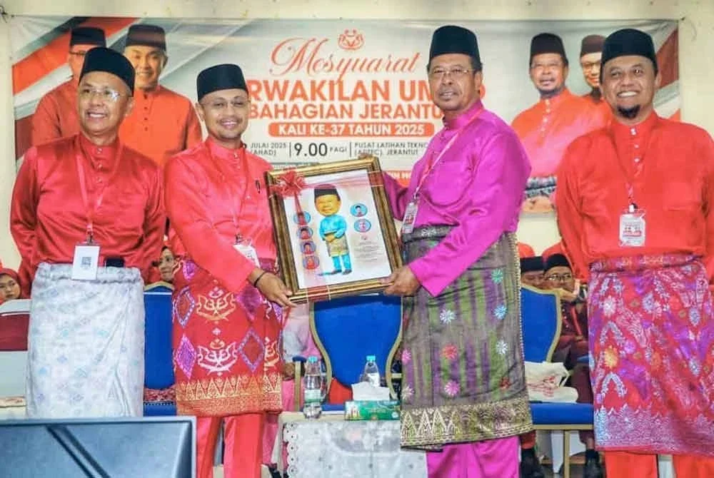 Abdul Rahman (dua dari kanan) menerima cenderamata daripada Haris selepas merasmikan Mesyuarat Perwakilan UMNO Bahagian Jerantut pada Ahad.