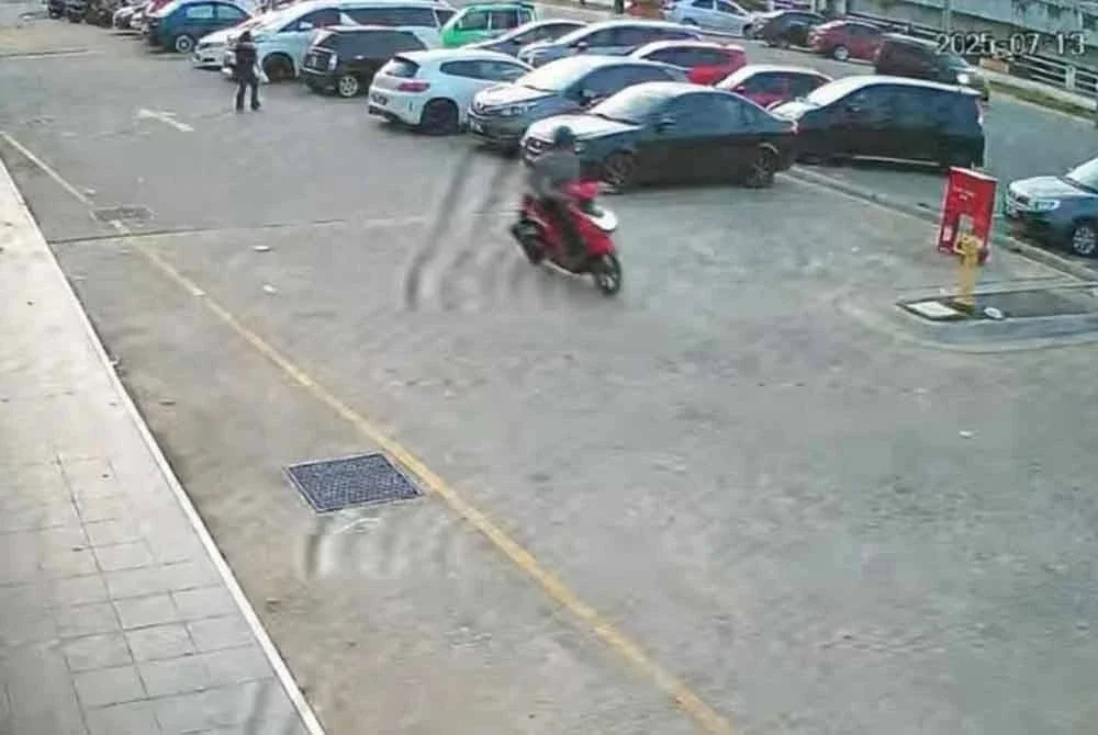 Tangkap layar CCTV yang memaparkan seorang penunggang motosikal meragut wanita di hadapan sebuah kafe di Lotus Lembah Sireh, Kota Bharu pada Ahad. Foto tular