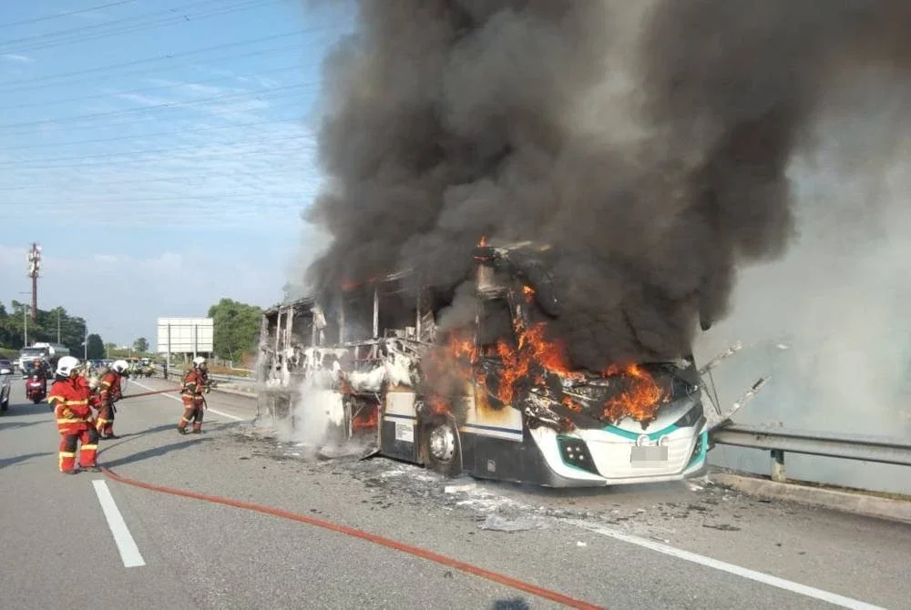 Anggota bomba memadamkan kebakaran sebuah bas persiaran di Lebuhraya MEX pada Rabu.