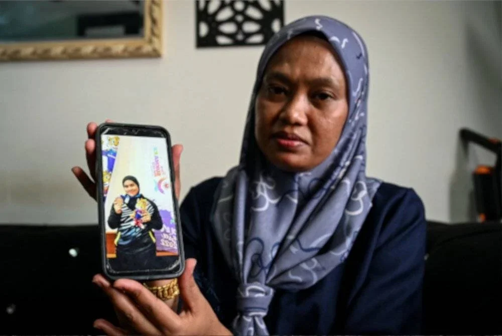 Ibu, Rusmailaili Samsuri, 43, menunjukkan gambar anaknya atlet angkat berat Sukan Malaysia (SUKMA) Terengganu, Allahyarham Siti Noralyaa Mat Marzuki pada Majlis Penyampaian Faedah Pengurusan Mayat (FPM) di Taman Batin Perdana pada Rabu. Foto Bernama