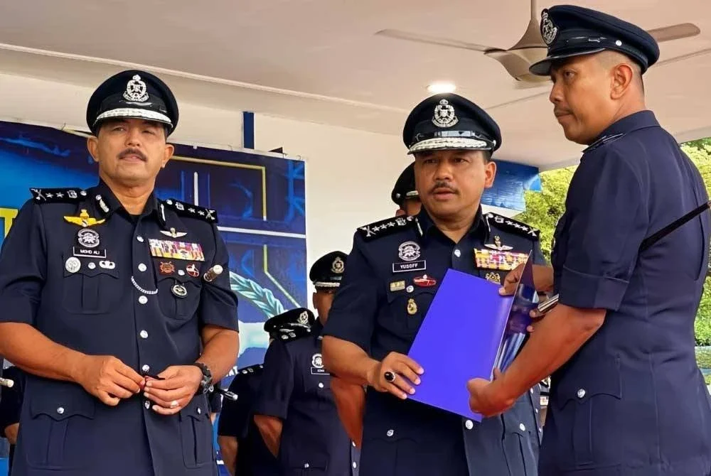 Mohd Yusoff (tengah) menyampaikan watikah kenaikan pangkat kepada pegawai terlibat semasa Perhimpunan Bulanan di Ibu Pejabat Polis Kontinjen (IPK) Kelantan di Kota Bharu pada Khamis.