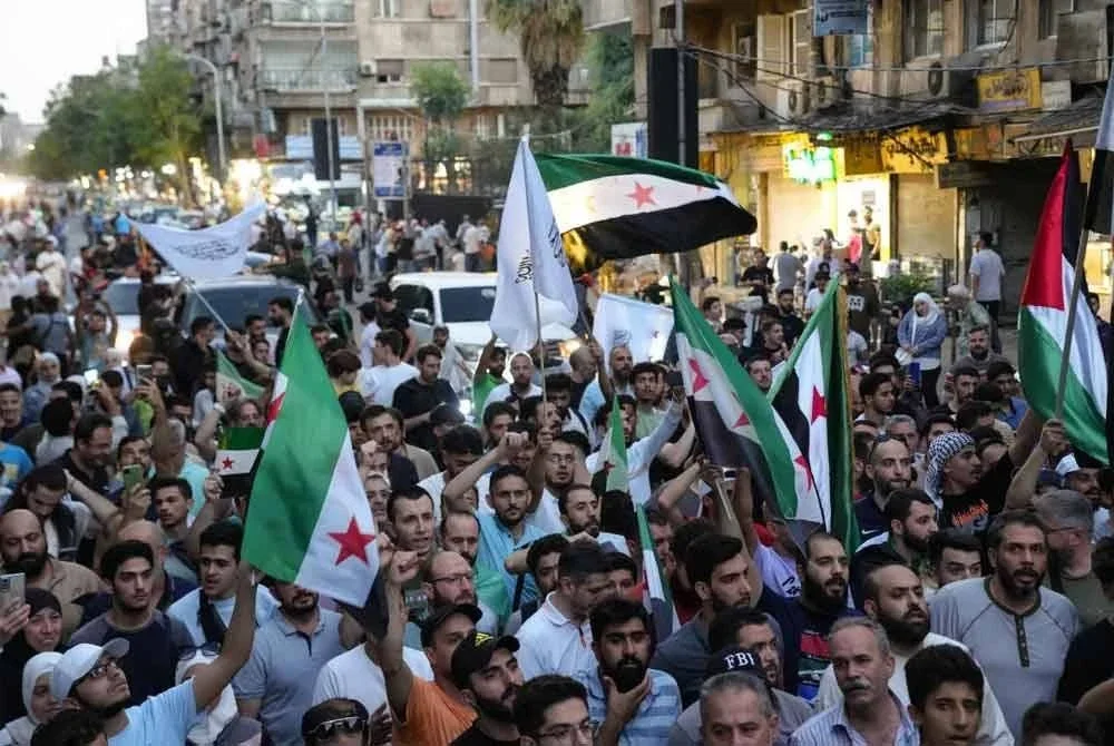 Penduduk Syria berarak ketika melancarkan protes bagi membantah campur tangan ketenteraan Israel di negara itu.