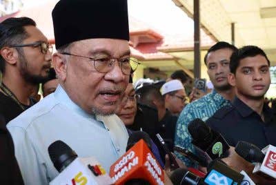 Anwar (kiri) ditemui media selepas menunaikan solat Jumaat di Surau Al-istiqlal Presint 14 pada Jumaat. Foto Bernama