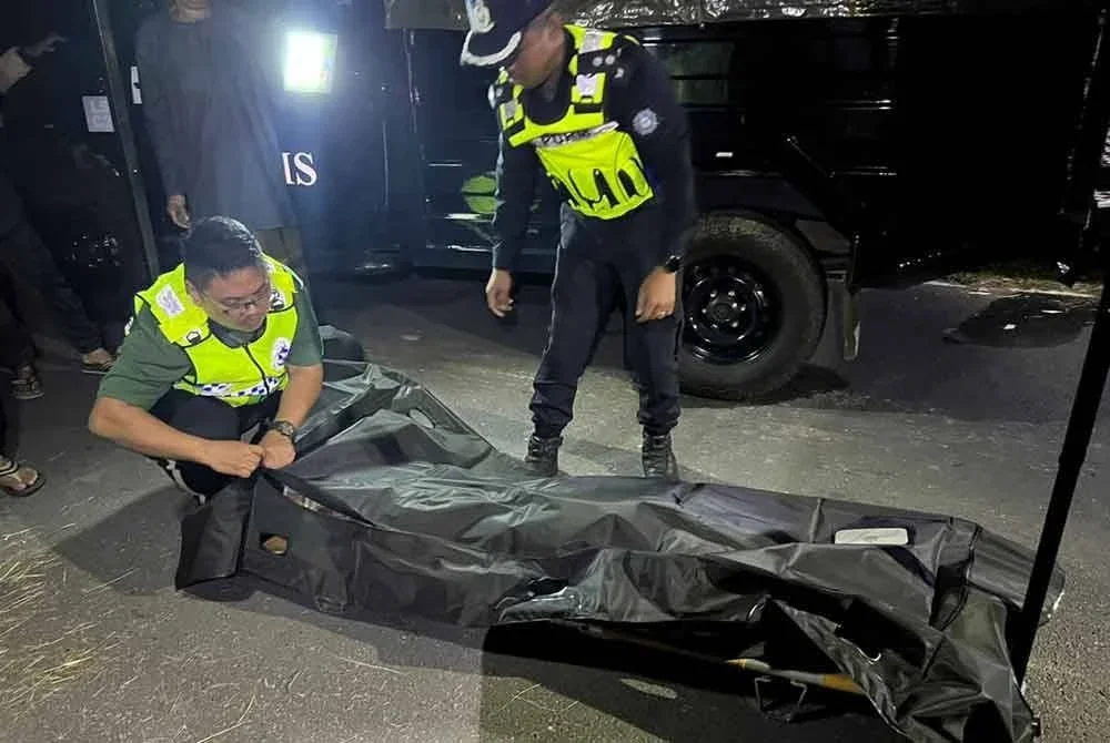 Anggota polis membantu mengangkat mayat mangsa sebelum dibawa ke hospital untuk proses bedah siasat. Foto ihsan Polis Rompin.