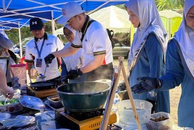 Steven mencuba membuat kuih ketayap pada program komuniti di Jeti Nelayan, Kampung Telok Pelandok pada Ahad.