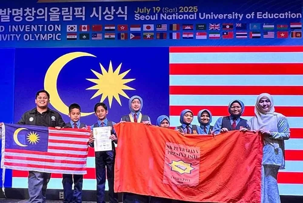 Muhammad Shahrol (kiri) dan Cikgu Asa'adatul Jannah Kamaruddin (kanan) bersama pasukan inovasi SK Putrajaya Presint 18 (1) selepas diumumkan pemenang anugerah emas WICO.
