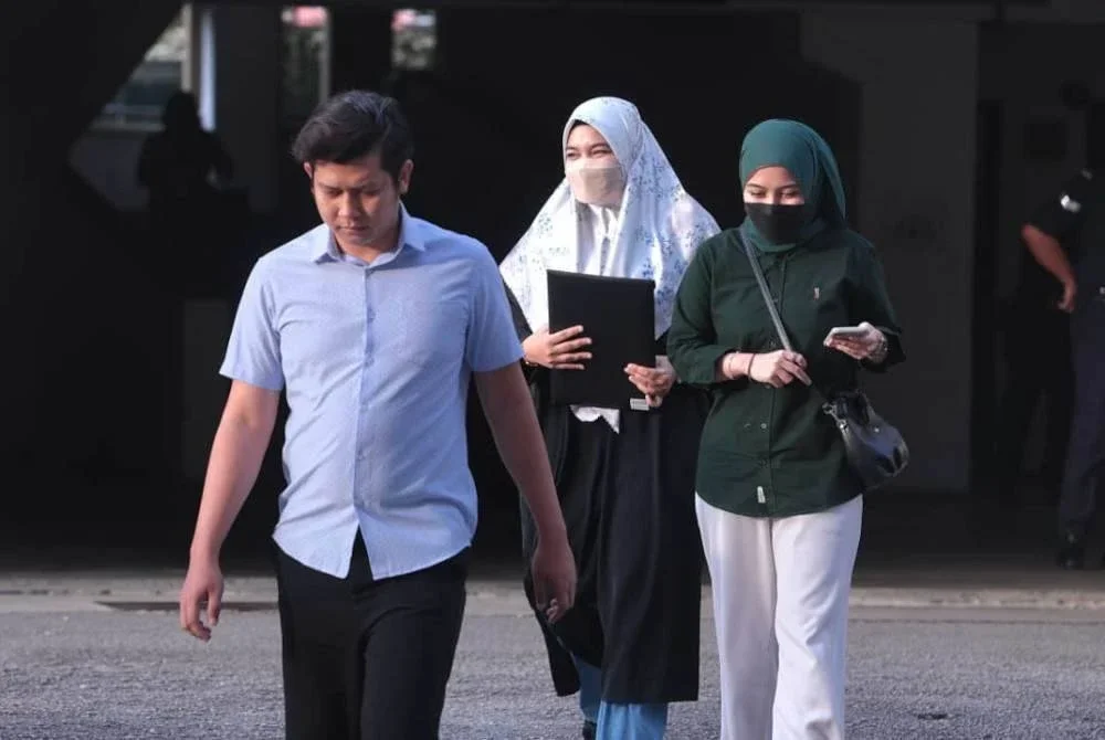 Ismanira (tengah) bersama Zaim Ikhwan (kiri) keluar dari Mahkamah Sesyen Petaling Jaya pada Isnin.