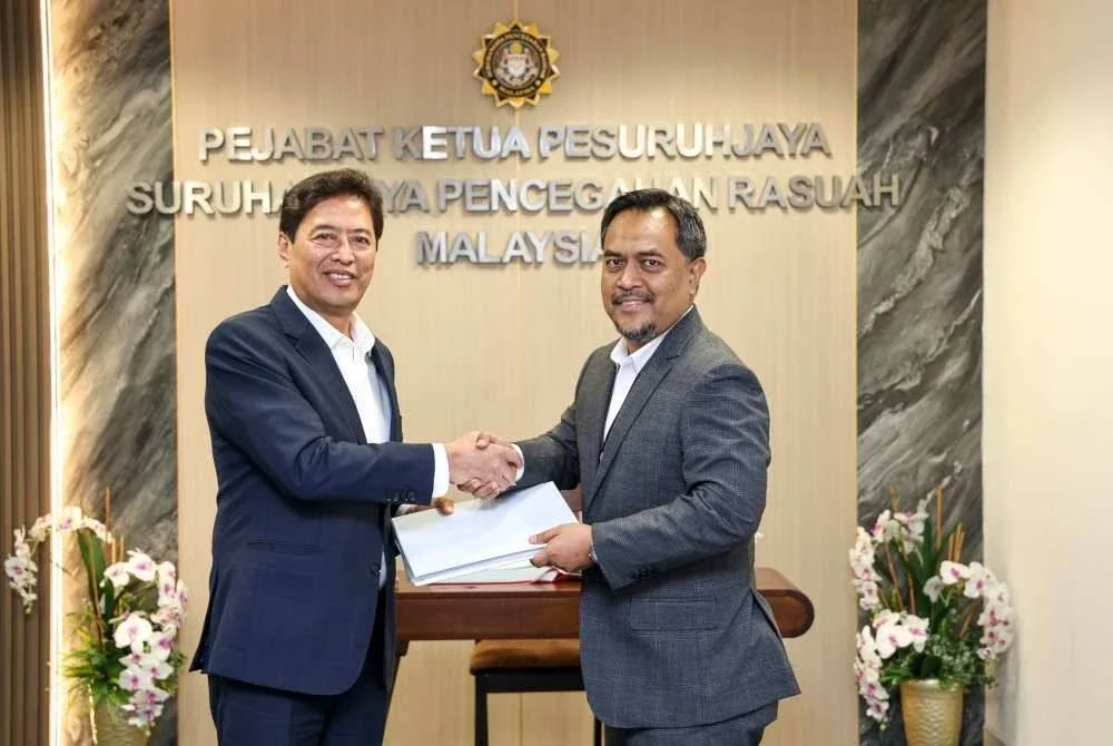 Azam (kiri) menerima sebanyak 13 Borang Perisytiharan Harta CEO dan Ketua Syarikat Operasi syarikat-syarikat di bawah daripada Rosman di Ibu Pejabat SPRM Putrajaya pada Isnin. Foto SPRM