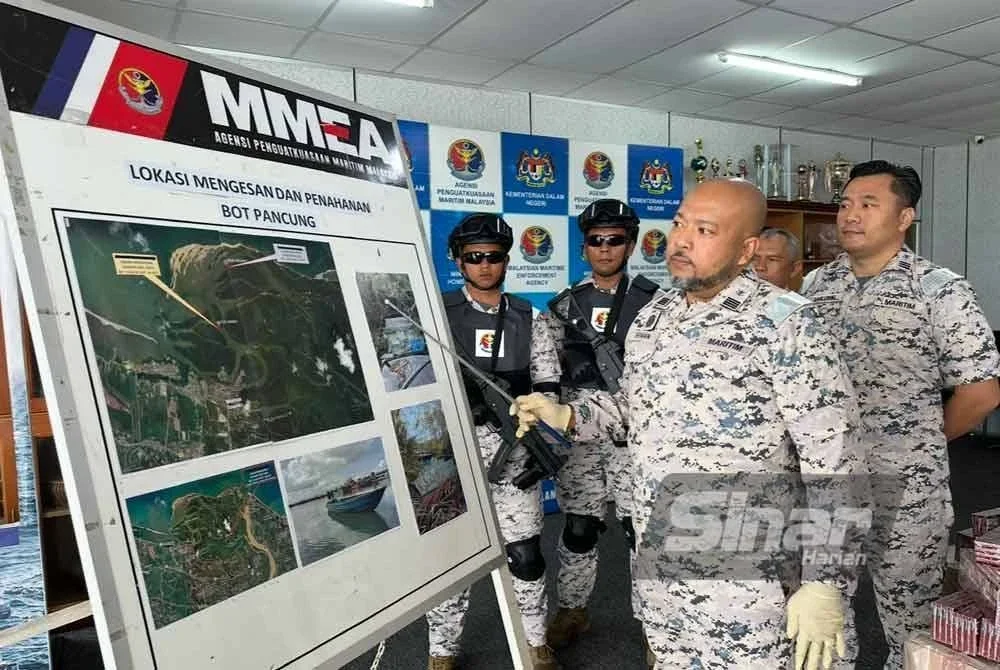 Erwan Shah (tengah) menunjuk peta lokasi penahanan bot pancung yang membawa muatan rokok seludup di perairan Kelantan hasil risikan dan rondaan Maritim Malaysia.
FOTO SINAR HARIAN - ADILA SHARINNI WAHID
