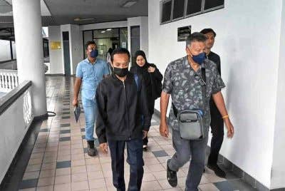 Kau Lik (tengah) didakwa di Mahkamah Sesyen Melaka pada Selasa atas tuduhan memberi suapan.