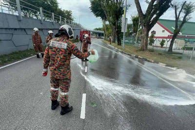 Anggota bomba melakukan kerja-kerja membersihkan kawasan tumpahan minyak diesel yang berlaku pada petang Selasa.