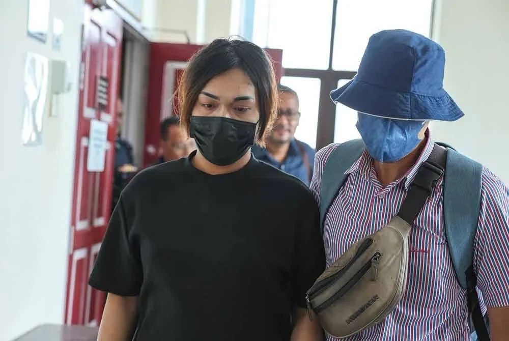 Mohamad Haikal Izzuwan (kiri) diiringi pegawai penguat kuasa agama selepas pendakwaan di Mahkamah Tinggi Syariah Kuala Terengganu pada Rabu.