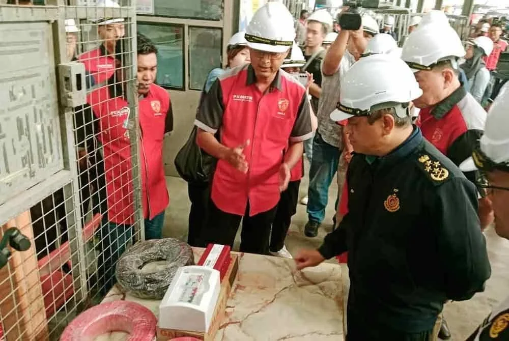 Aedy Fadly (kanan) diberikan penerangan ketika melawat kilang pembuatan badan bas di Telok Gong pada Rabu.