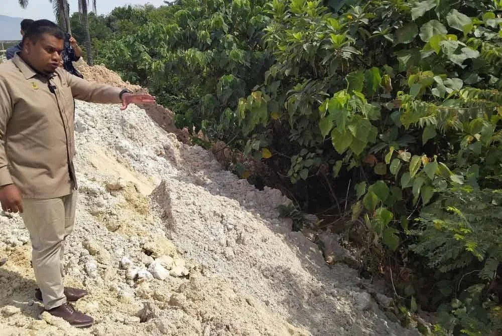 Muhamad Arafat menunjukkan anak sungai berhampiran kawasan perlombongan koalin ketika meninjau keadaan kawasan tersebut bersama wakil penduduk dan kakitangan PTG Perak di sini pada Rabu.