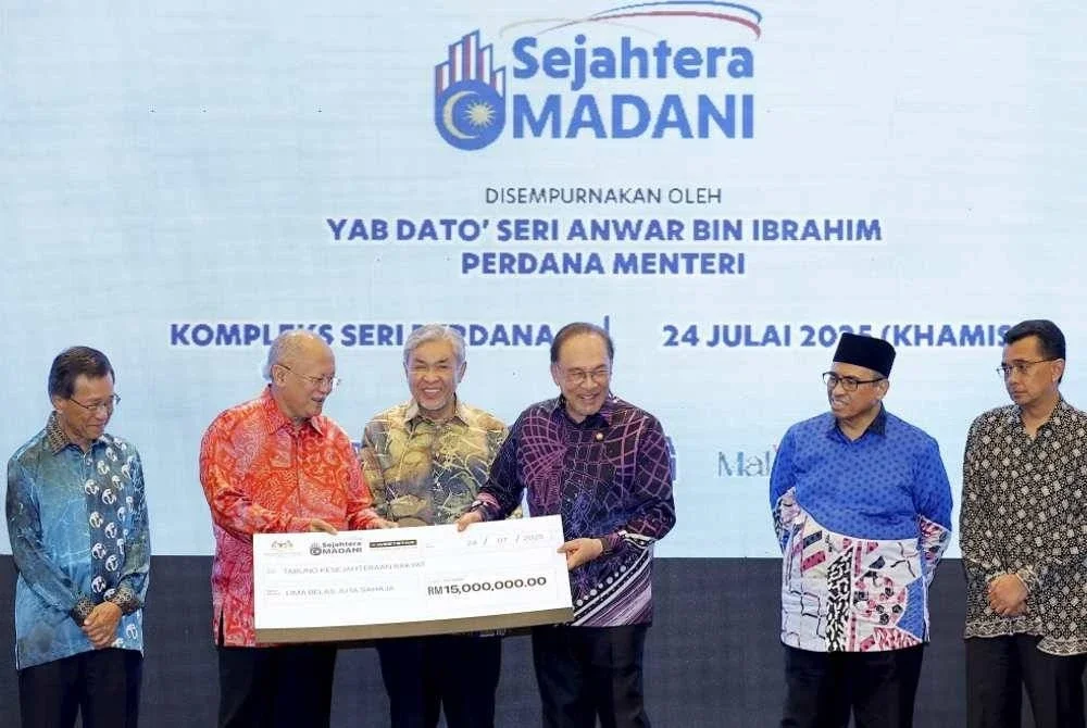 Anwar (tiga dari kanan) menerima sumbangan daripada Pengarah Urusan Kumpulan Weststar, Tan Sri Dr Syed Azman Syed Ibrahim (dua kiri) selepas meluncurkan Sejahtera Madani di Kompleks Seri Perdana pada Khamis. Foto Bernama
