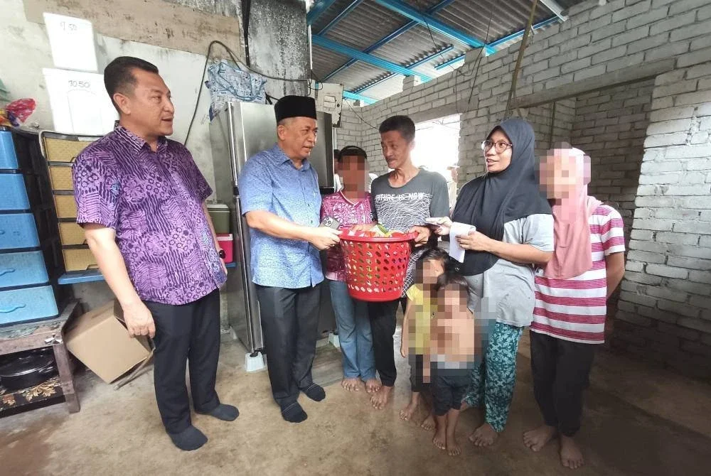 Ahmad Razif (dua dari kanan) menyerahkan sumbangan kepada keluarga tersebut ketika kunjungan pada Khamis.