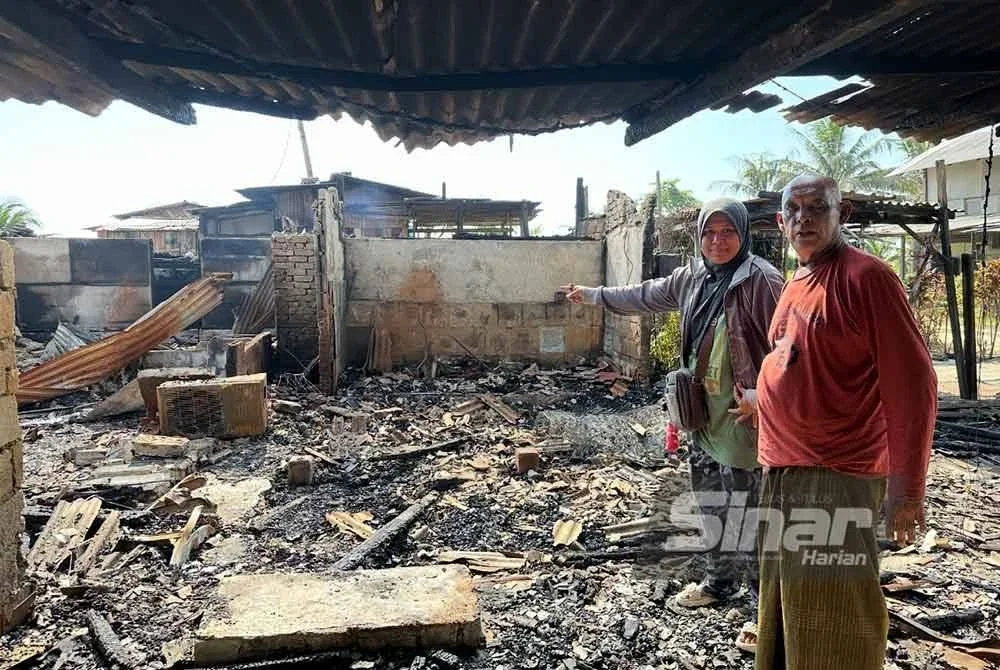 Abdullah (kanan) dan Ruzila (kiri) menunjukkan bahagian rumah dan chalet yang musnah. FOTO SINAR HARIAN - ADILA SHARINNI WAHID