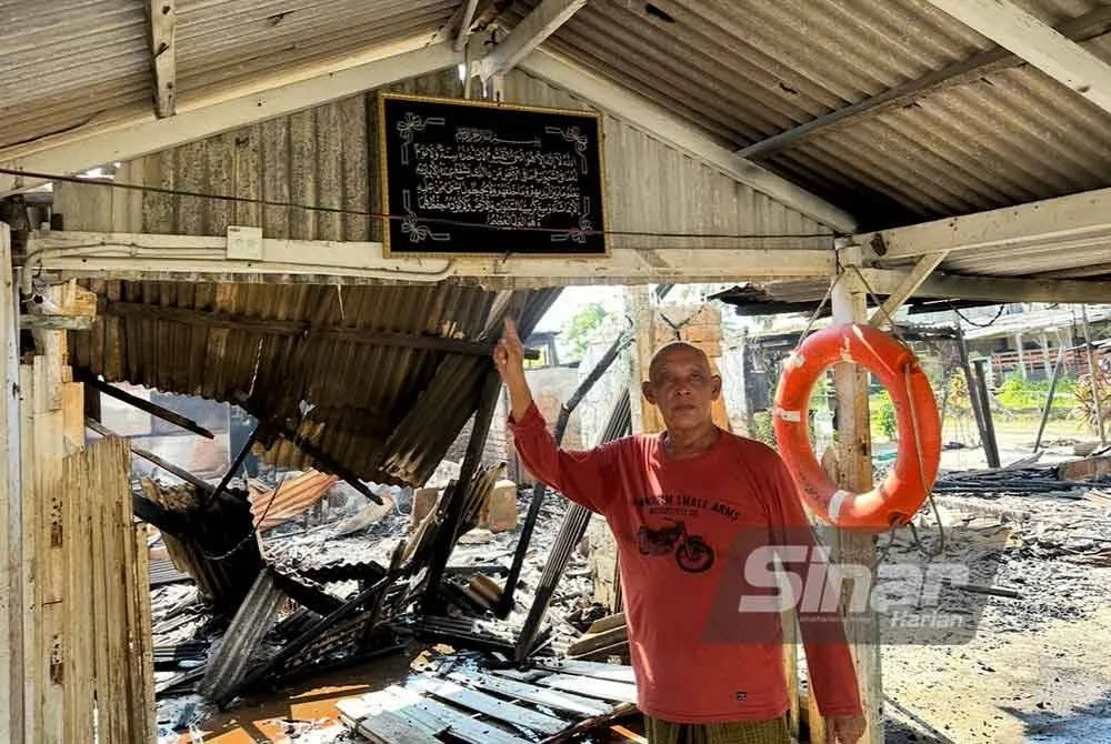 Abdullah menunjukkan ayat Kursi yang digantung di dinding tidak terbakar. FOTO SINAR HARIAN - ADILA SHARINNI WAHID