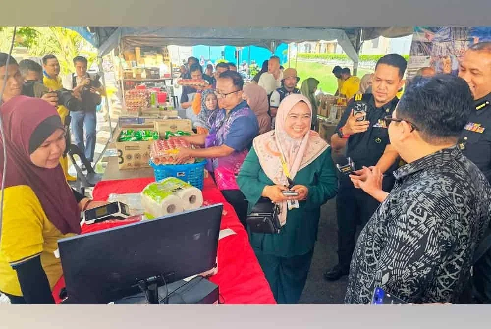 Kamalludin (kanan) meninjau proses jualan PJRM di Bangunan Persekutuan Greentown, Ipoh pada Jumaat.