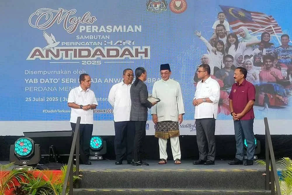 Saifuddin (dua, kanan) mengiringi Anwar menyampaikan anugerah ikon antidadah kepada Wan Aminuddin Wan Ismail atau Ameng Spring pada Sambutan Hari Antidadah 2025 di Dataran Darulaman, Jitra pada Jumaat. Hadir sama Muhammad Sanusi (dua kiri).