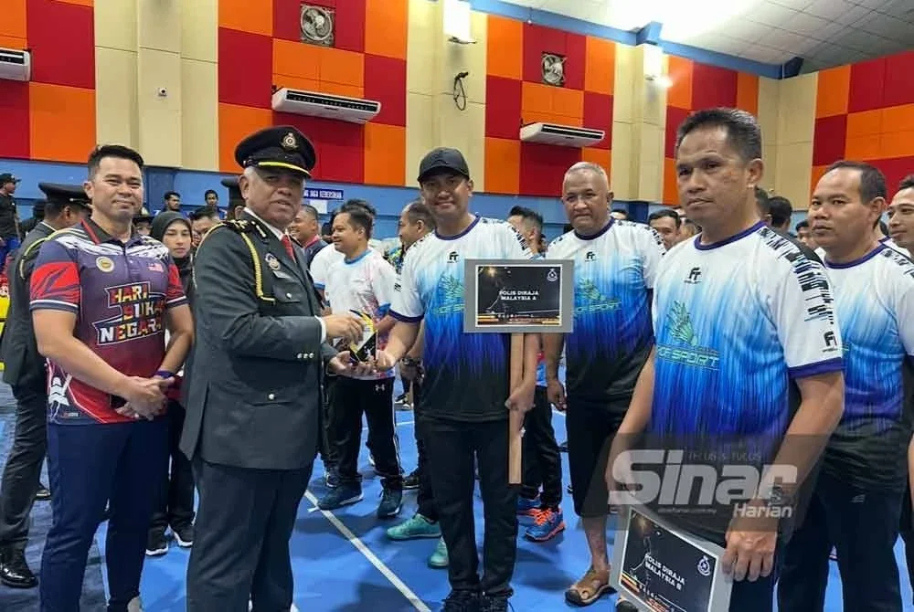 Aris (dua dari kiri) menyampaikan cenderamata kepada peserta badminton dari PDRM Kelantan.
