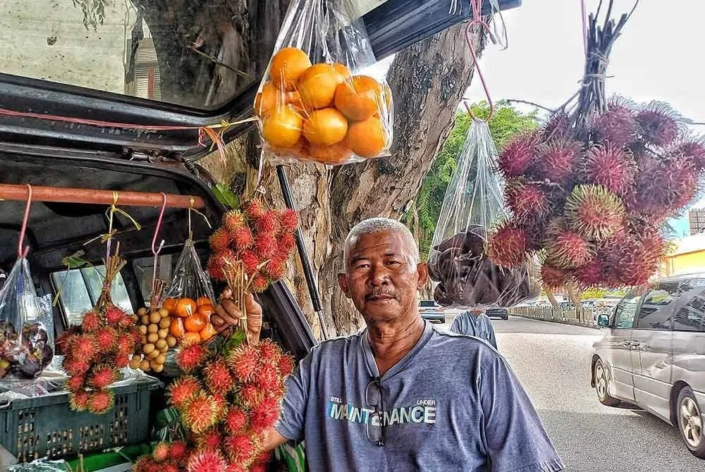 Pokya menunjukkan buah-buahan yang dijual di dalam van miliknya.