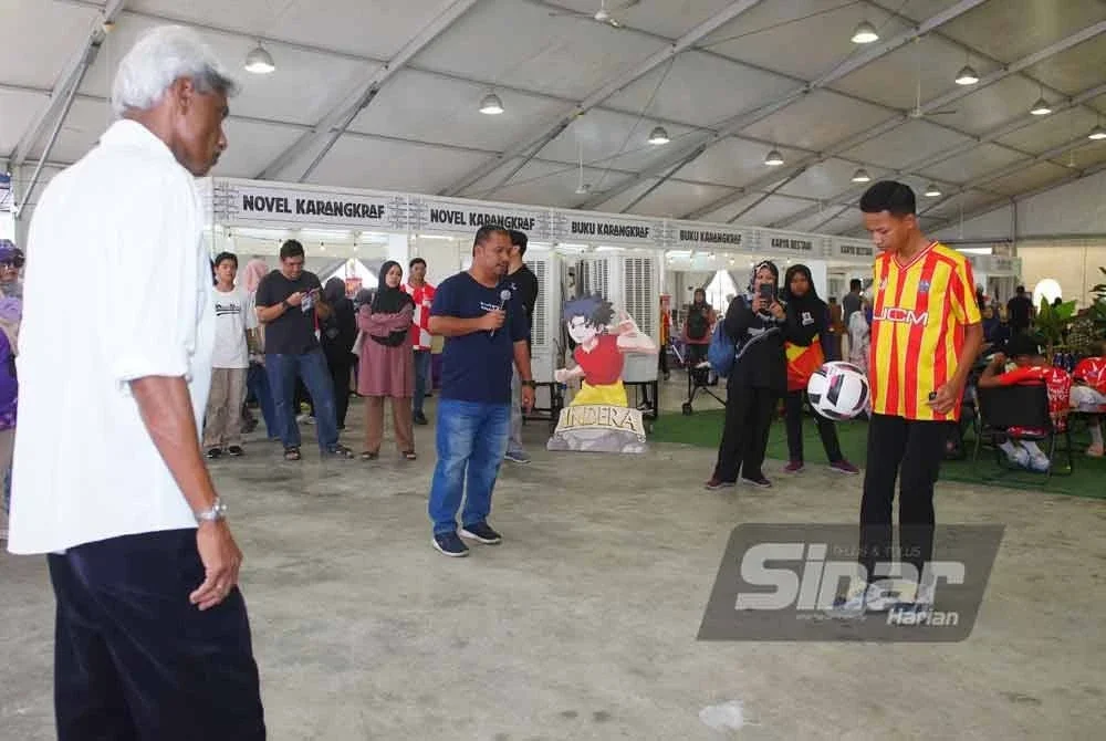 Rajagobal (kiri) melihat salah seorang pengunjung timbang bola dalam program Game On pada Sabtu.