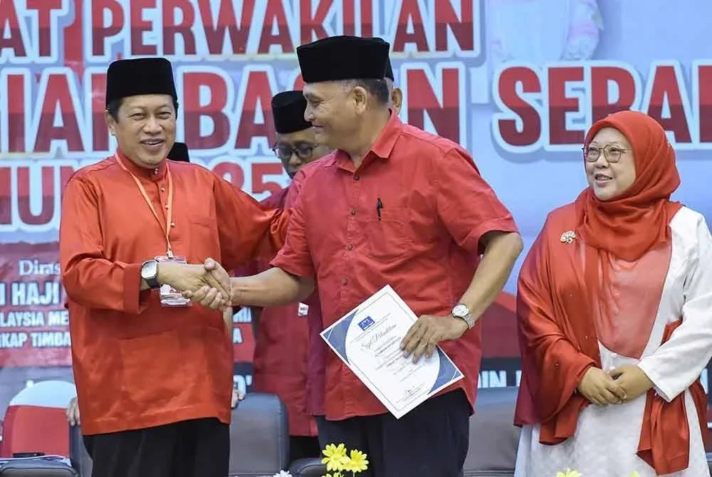 Ahmad (kiri) menyerahkan sijil pelantikan Pengerusi Pusat Daerah Mengundi bagi kawasan Parlimen Bagan Serai sempena Mesyuarat Perwakilan UMNO Bahagian Bagan Serai di Dewan Dato' Zainal Abidin Zin, Bagan Serai pada Sabtu.