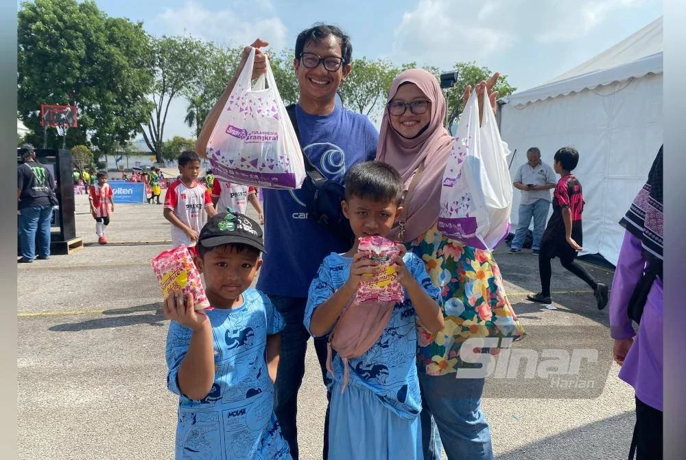 Norazuah sekeluarga ceria bersama barangan yang dimenangi ketika menyertai permainan B4U ketika mengunjungi Karnival Siang Malam Karangkraf 2025. 