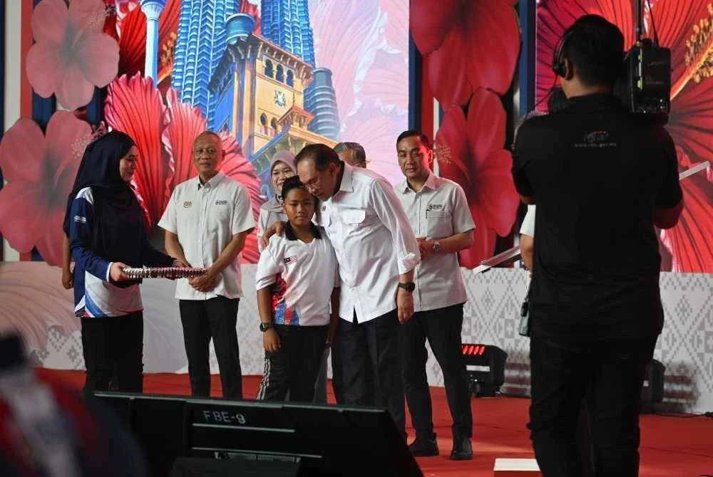 Anwar (kanan) pada Majlis Peluncuran Bulan Kebangsaan dan Kibar Jalur Gemilang 2025, di Tanjung Emas pada Ahad. Foto Jabatan Penerangan