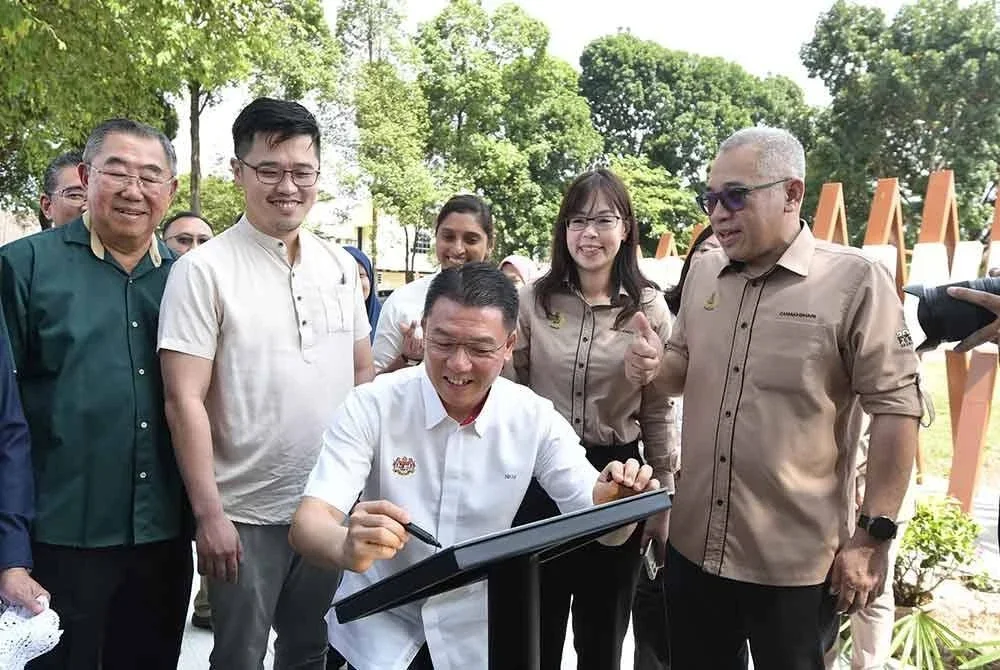 Kor Ming menandatangani plak simbolik merasmikan Taman Rekreasi Madani di Taman Canning pada Ahad.