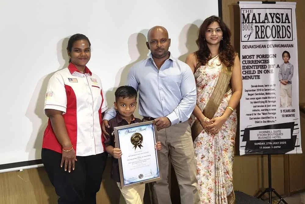 Menaga (kiri) menyampaikan sijil MBOR kepada Devakshean yang ditemani ibu bapanya.