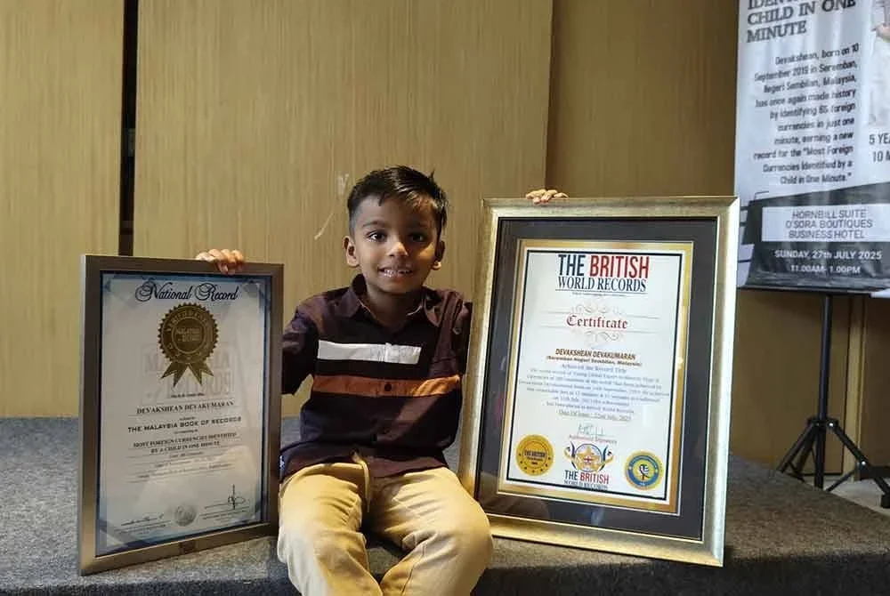 Devakshean menunjukkan rekod MBOR dan British World Record yang diterimanya.
