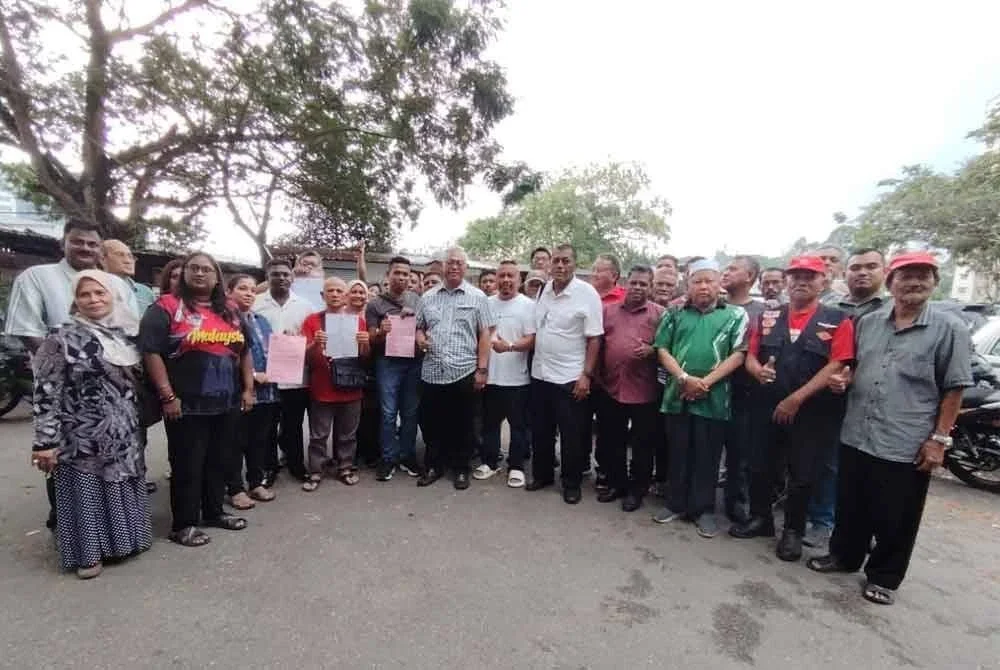 Noh (tengah) bersama penjaja Lembah Subang 1 selepas berakhir sesi dialog di kawasan berkenaan pada Ahad.