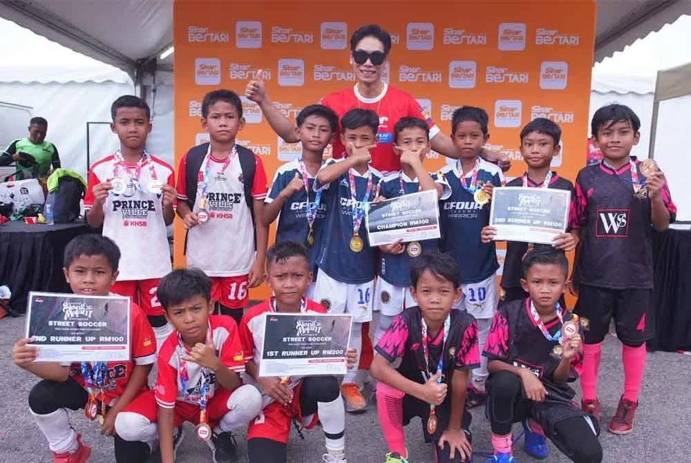 Pemenang kategori B10 Pertandingan Street Soccer menunjukkan hadiah yang dimenangi mereka.