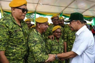 Saifuddin Nasution beramah mesra bersama sebahagian anggota Rela selepas merasmikan Sambutan Hari Ulang Tahun Rela Ke-53 di Dataran Kulim pada Ahad. Foto Bernama