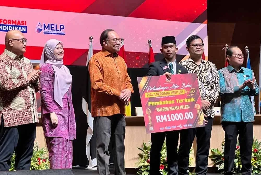 Perdana Menteri, Datuk Seri Anwar Ibrahim menyampaikan hadiah kepada pemenang Pertandingan Akhir Bahas Piala Perdana Menteri ke-50 di Putrajaya.