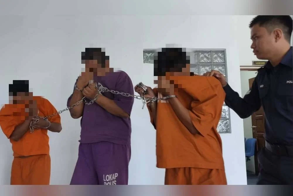 Suspek (dua dari kiri) ketika dibawa keluar dari Mahkamah Majistret di sini pada Isnin.