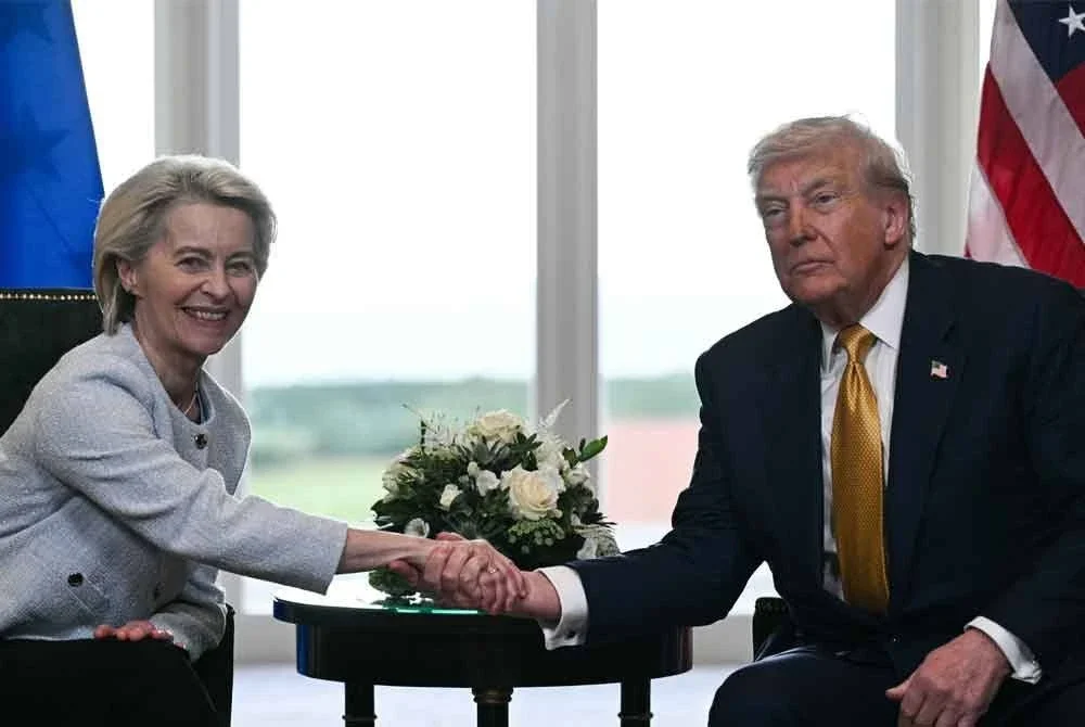 Trump (kanan) bersalaman dengan Von der Leyen selepas mencapai kesepakatan dalam perjanjian perdagangan AS-EU. - Foto: AFP