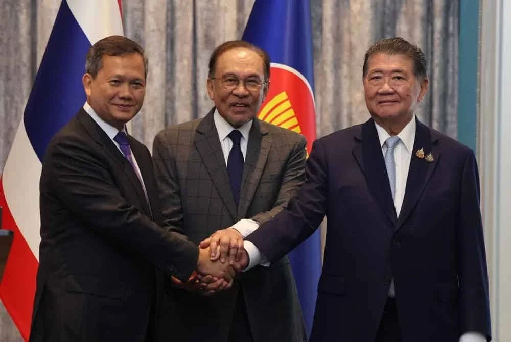 Anwar (tengah) menyaksikan Hun Manet (kiri) bersalaman dengan Phumtham Wechayachai (kanan) selepas Mesyuarat Khas Bersama di Kompleks Seri Perdana. Foto Bernama